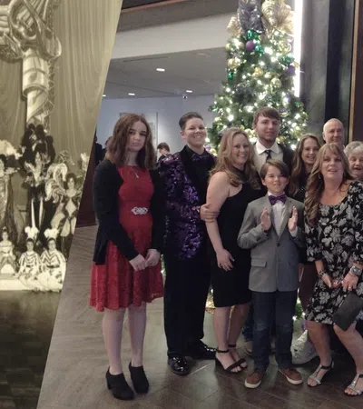 a group of people posing for a photo in front of a christmas tree