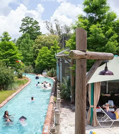 a pool with people in it and a gazebo with trees in the background