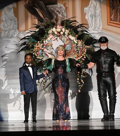 a group of people standing on a stage with a large bouquet of flowers