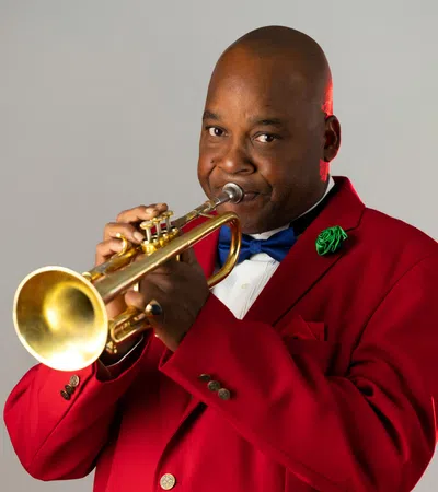 a man in a red uniform playing a trumpet