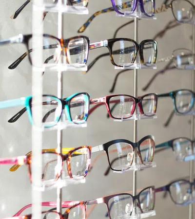 Colorful display of stylish eyeglasses arranged neatly on a wall for selection.