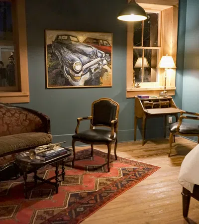 a living room with a desk and chairs