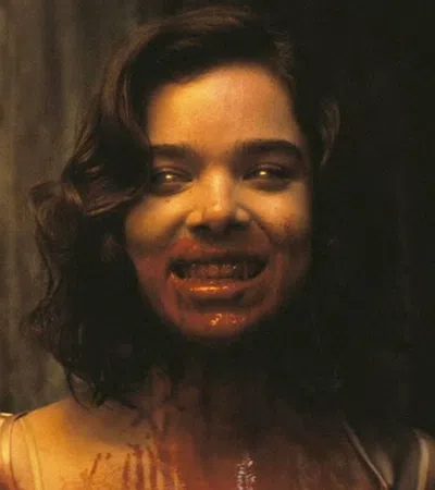 A woman with a sinister smile and blood on her face in a dark setting, evoking horror and suspense.