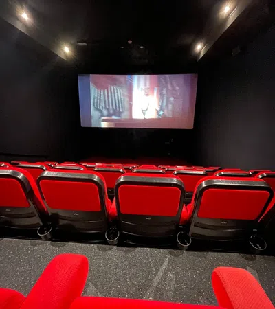 a large room with red chairs and a tv on the wall