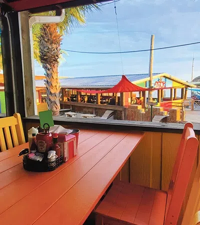 a table with chairs and a boat in the background