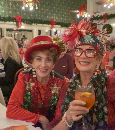 a couple of women wearing red hats and holding drinks