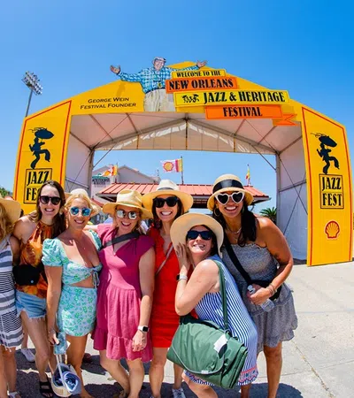 a group of people posing for a photo in front of a yellow tent
