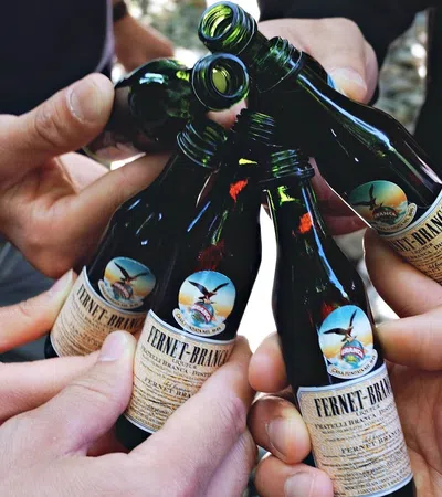 a group of hands holding bottles