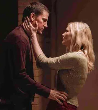 Couple sharing an intimate moment in a dimly lit room with warm tones and soft expressions