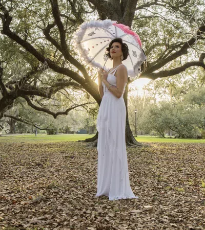 a person in a white dress holding an umbrella