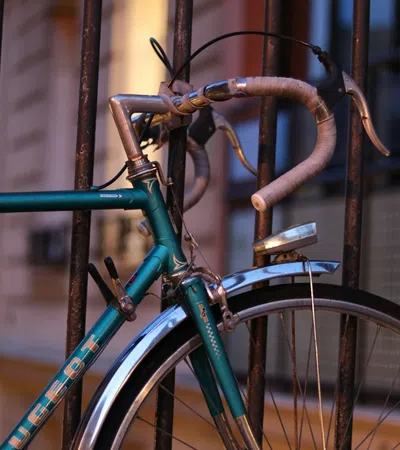 Close-up of a vintage bicycle parked against a railing during sunset.