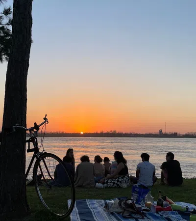a group of people sitting on a bench by the water