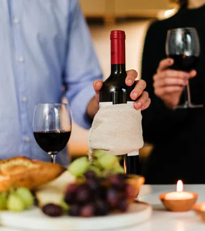 a couple of people holding wine glasses and a plate of food