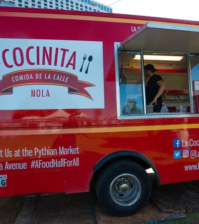Red La Cocinita food truck parked with open service window and contact info at Pythian Market New Orleans