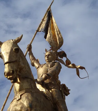 a statue of a man riding a horse with a sword and a woman on a horse