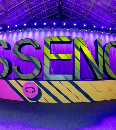 Large 3D letters spelling ESSENCE at the 30th Essence Festival with purple lighting in a convention hall.