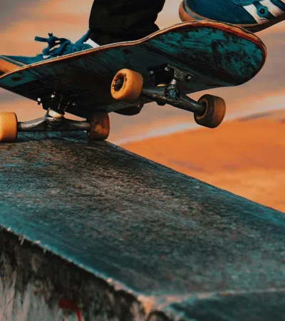 Close-up of skateboard wheels grinding on a concrete ledge during a sunset skate session.