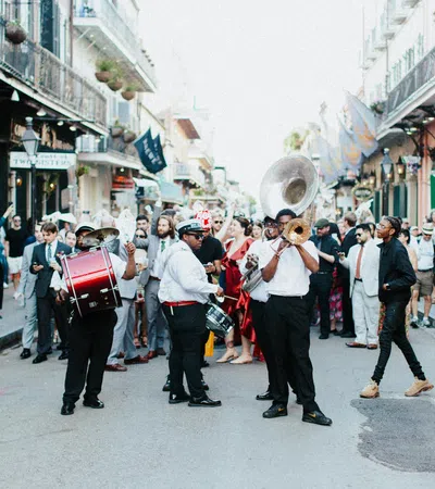 Street parade with a lively brass band playing music and a crowd of people enjoying the festive atmosphere.