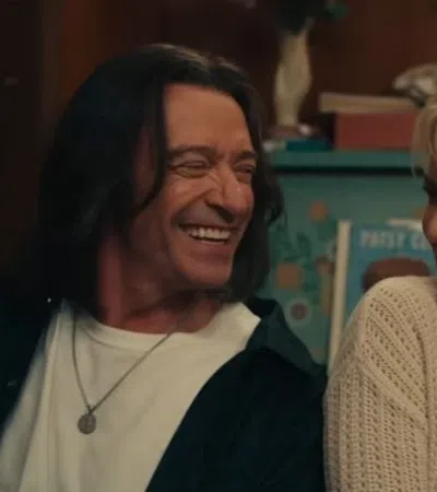 Man and woman smiling warmly at each other in a cozy indoor setting with soft lighting.