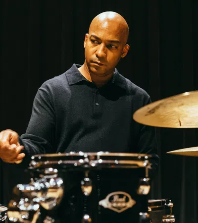 A focused musician playing drums, capturing rhythm and passion in a live performance setting.