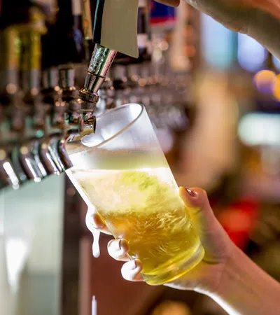 a close-up of a hand pouring a glass of liquid