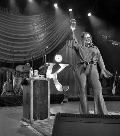a person on a stage with a microphone and a guitar