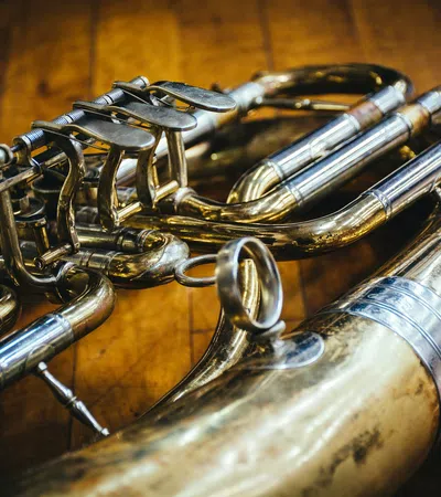 Close-up of a brass saxophone with detailed keys and tubing on a wooden surface, highlighting its polished metal.