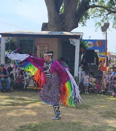 a person in a colorful garment dancing in front of a crowd