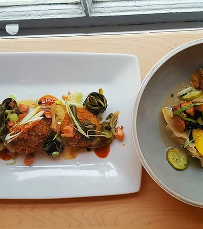 Delicious plated dish featuring vegetables and crispy fried items on a wooden table.
