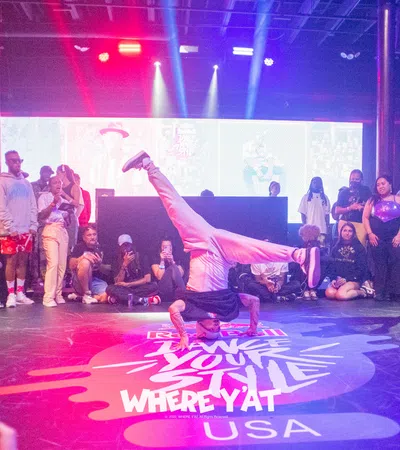 a person doing a handstand on a stage with a crowd watching