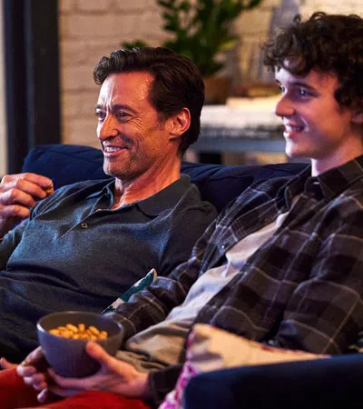 Hugh Jackman et al. sitting on a couch and smiling