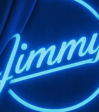 Neon blue sign announcing Jimmy's Music Club coming soon, with curtain partially covering it.