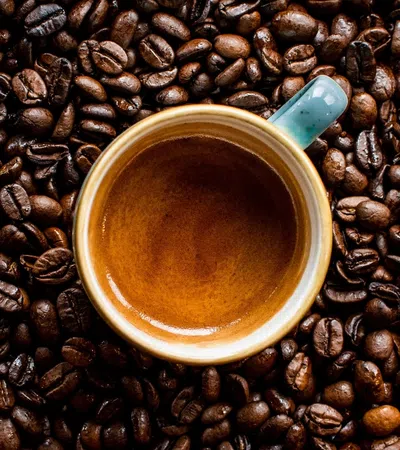 a cup of coffee on a coffee beans