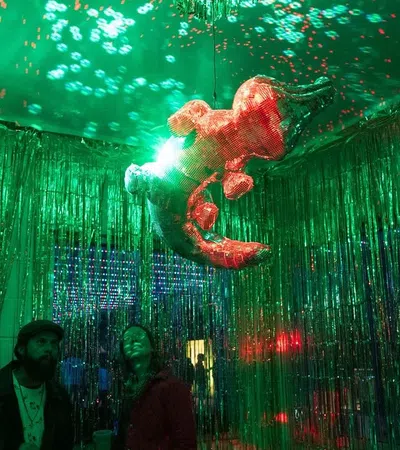 a person holding a fish in the air in front of a crowd