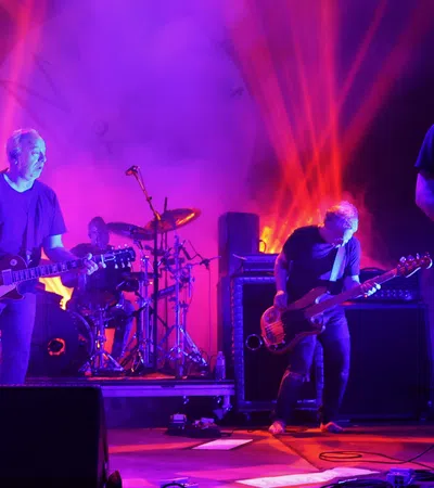 a group of men playing guitars on a stage