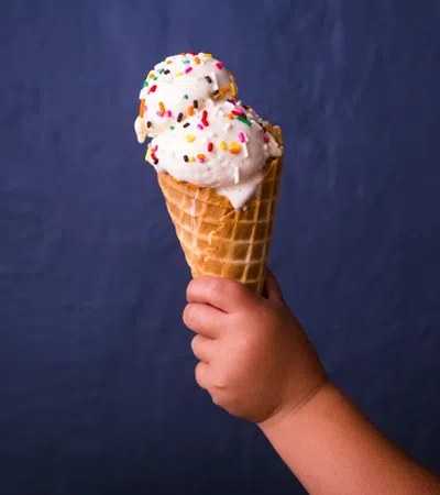 a person holding an ice cream cone