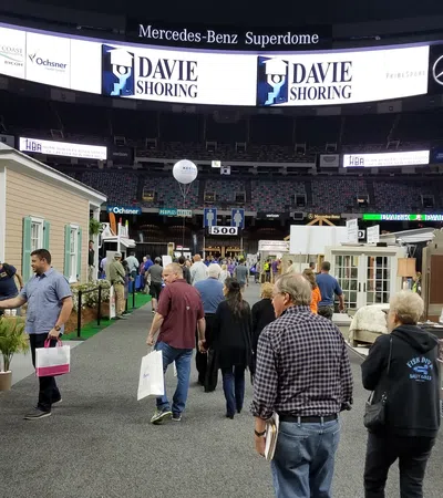 Visitors explore home and kitchen exhibits at an indoor trade show in Mercedes-Benz Superdome.