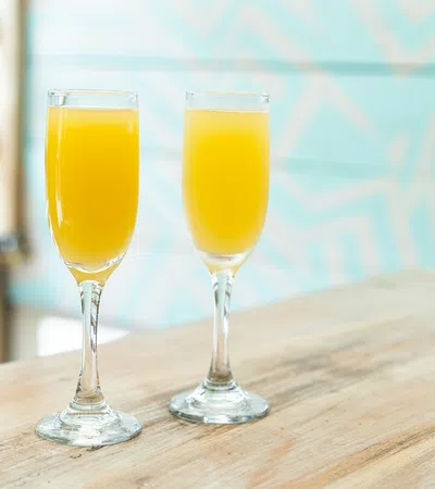 two glasses of orange juice on a table