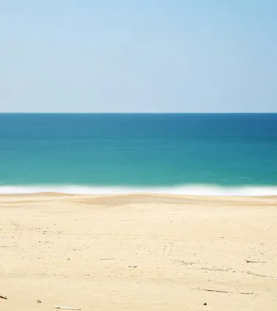a sandy beach with blue water