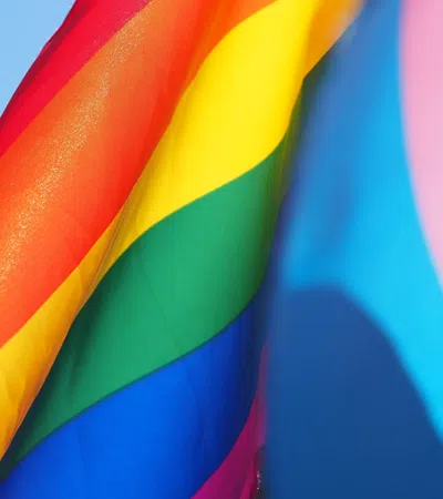 Close-up of a vibrant rainbow pride flag waving with bright red, yellow, green, blue, and pink colors.