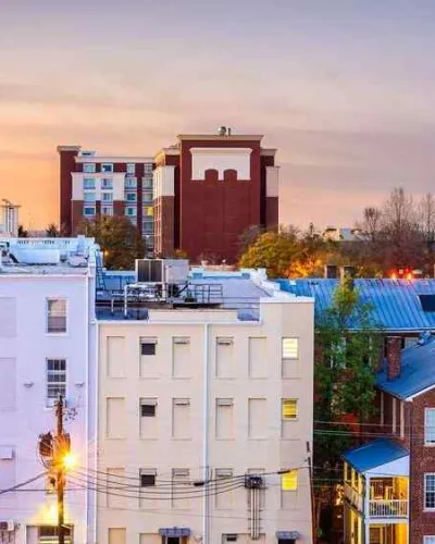 Colorful urban skyline at sunset with historic buildings and modern architecture in a vibrant city.