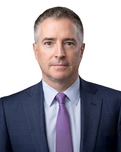 Professional middle-aged man in a blue suit and purple tie against a white background