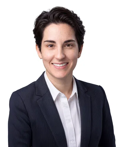 Professional young woman with short dark hair in a pinstripe suit and white shirt smiling against white background