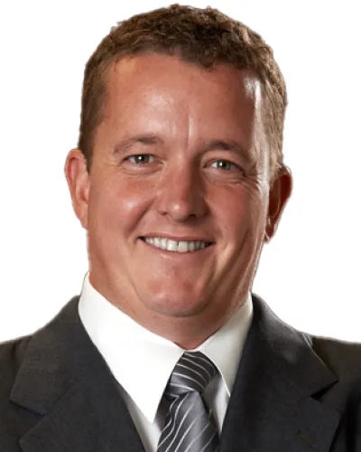 Smiling middle-aged man in gray suit and striped tie against white background
