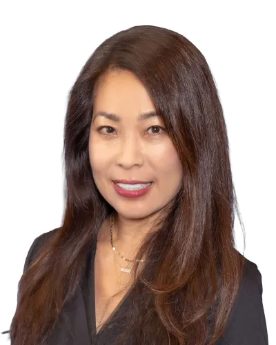 Smiling woman with long brown hair in a black blouse against white background.