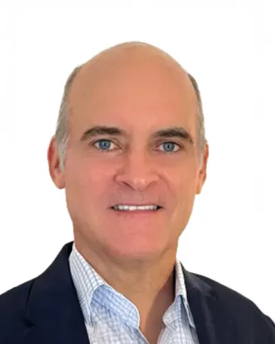 Smiling middle-aged man wearing a dark blazer and checkered shirt on a white background