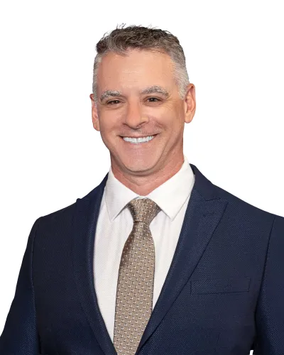 Smiling professional man wearing a dark suit and striped tie against a white background