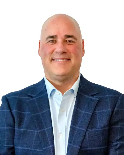 Smiling bald man wearing a blue checkered suit jacket and white dress shirt on a white background