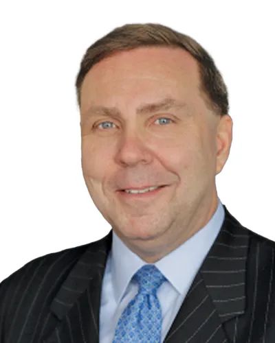 Smiling man in pinstripe suit with blue patterned tie and light blue shirt against white background