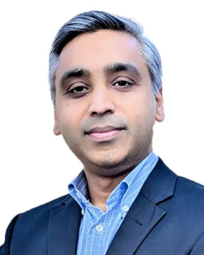 Professional portrait of a confident middle-aged man with gray hair wearing a blue shirt and dark blazer